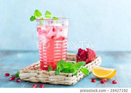 Infused pomegranate water with fresh lemon and ice Infused pomegranate water with fresh lemon and ice 28427192