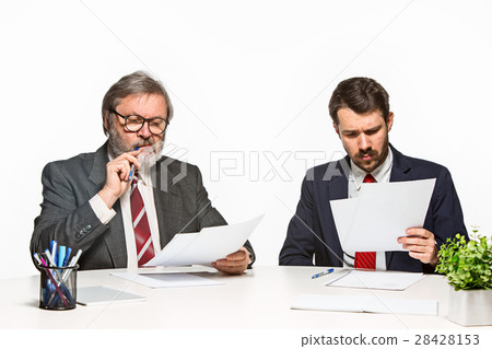 The two colleagues working together at office on 28428153