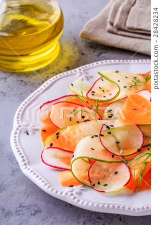 圖庫照片: vegetarian salad of carrot, cucumber and radish.