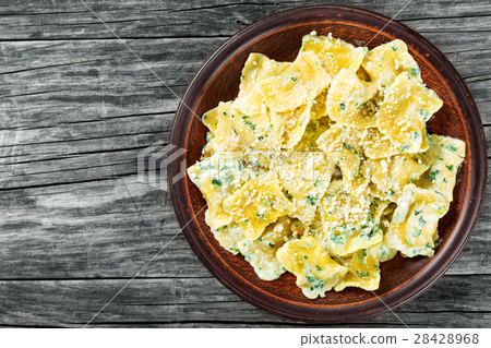 Italian ravioli smothered in creamy spinach sauce 28428968