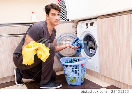 The young husband man doing laundry at home 28431333