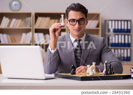 The young businessman playing chess in the office 28431360