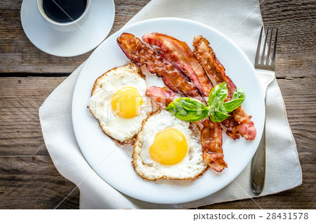 Fried eggs with bacon on the wooden table Fried eggs with bacon on the wooden table 28431578