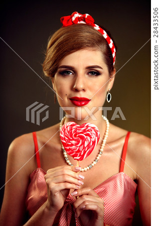 Woman eating lollipops. Girl in pin-up style hold 28433506