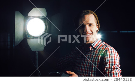 Man turning on studio light 28440138