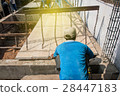 Worker placing cement floor in construction site 28447183