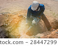 Worker drilling cement concrete floor with machine 28447299