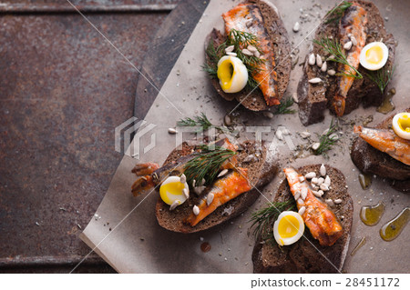 Sandwiches with sardines and quail eggs on right 28451172