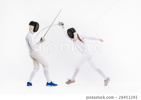 The woman and man wearing fencing suit practicing 28451291
