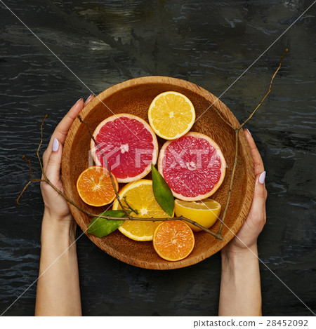 Grapefruit citrus fruit halves on wooden plate Grapefruit citrus fruit halves on wooden plate 28452092