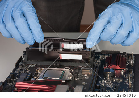 Close up of man hands with gloves installing Ram DDR4 memory mod Close up of man hands with gloves installing Ram DDR4 memory mod 28457019