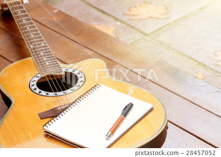 acoustic guitar with notebook and pen on wooden 28457052