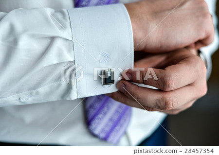 man in a tux fixing his cufflink 28457354