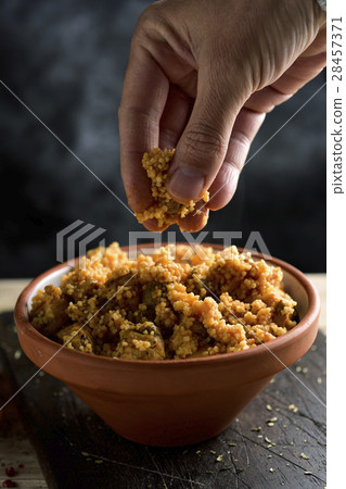 man eating couscous with his fingers 28457371