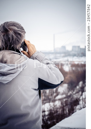 An elderly man talking on the phone and looking at 28457842