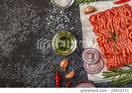 Raw minced meat on paper with onion, herbs and 28458131