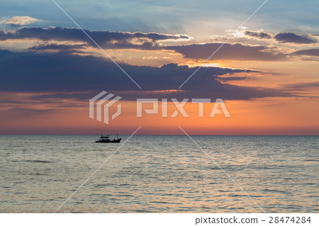 Small fishing boat over seacoast skyline Small fishing boat over seacoast skyline 28474284