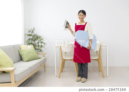 A smiling female apron with an iron A smiling female apron with an iron 28475169