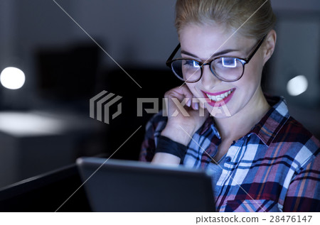 Amused IT girl using gadget in the dark lighted 28476147