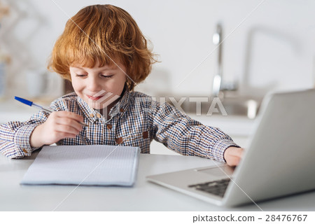 Bright intelligent child doing his homework Bright intelligent child doing his homework 28476767