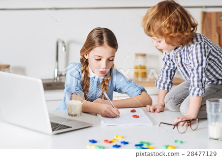 Smart diligent girl explaining her brother basic 28477129