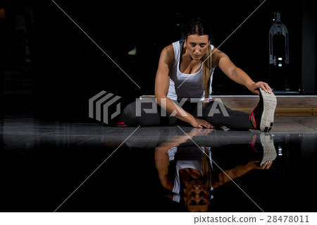 woman in a gym exercising, doing push ups. Dark woman in a gym exercising, doing push ups. Dark 28478011