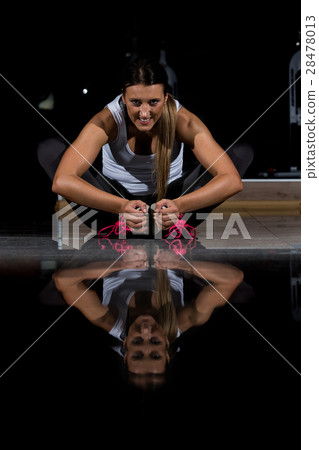 woman in a gym exercising, doing push ups. Dark woman in a gym exercising, doing push ups. Dark 28478013