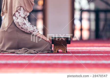 Young muslim woman reading koran in mosque Young muslim woman reading koran in mosque 28478547