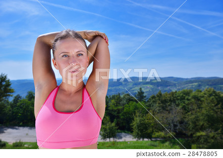 Young woman stretching her arms up while 28478805