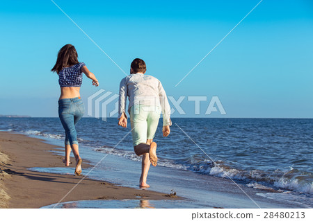 happy couple running on the beach 28480213
