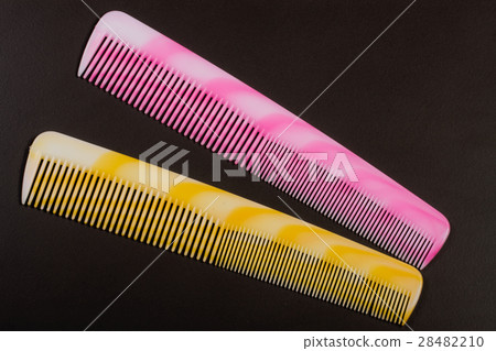 Two different colored hairbrushes on a dark Two different colored hairbrushes on a dark 28482210