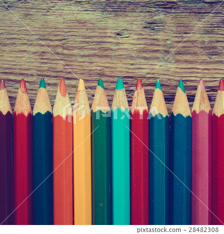 Row of colored drawing pencils on old desk. 28482308