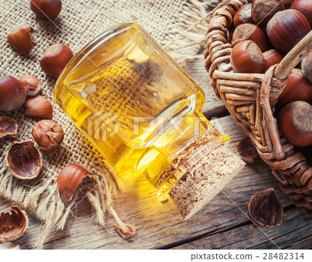 Bottle of nut oil and basket with filberts  28482314