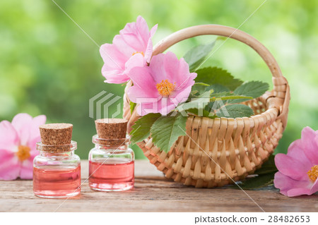 Basket with rose hip flowers and bottles of oil 28482653