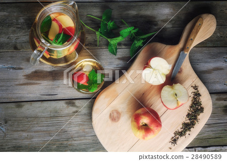 Tea in a jar and sliced apples on a cutting board Tea in a jar and sliced apples on a cutting board 28490589