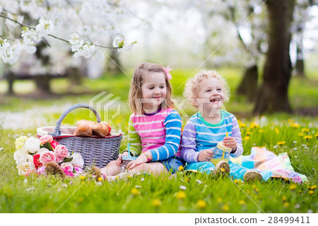 Kids having picnic in blooming garden 28499411