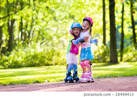 Kids roller skating in summer park 28499413