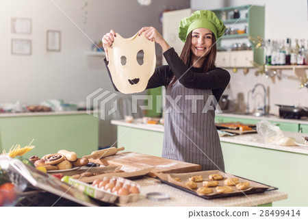 Young housewife having fun holding funny dough Young housewife having fun holding funny dough 28499414