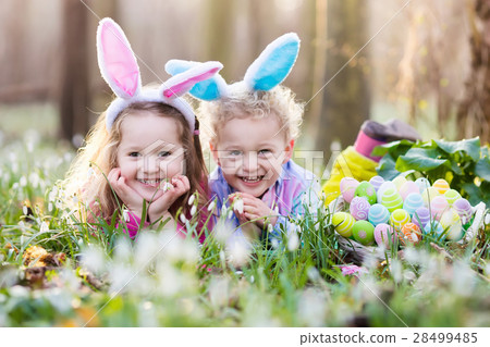 Kids on Easter egg hunt in blooming spring garden 28499485
