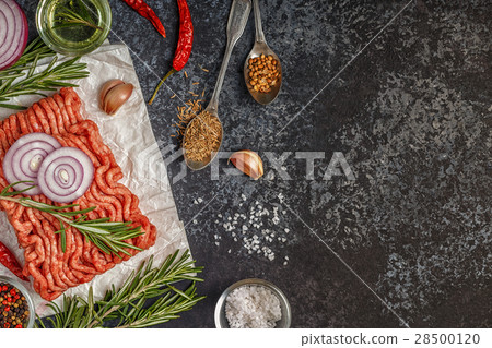 Raw minced meat on paper with onion, herbs and 28500120