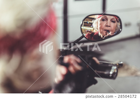 Serene pensioner rouging mouth by lipstick 28504172