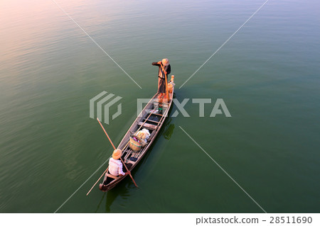 Two Burmese fishermen are fishing on a boat Two Burmese fishermen are fishing on a boat 28511690