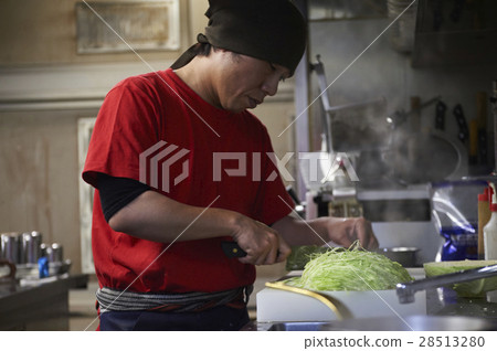 Male burning Hiroshima specialty okonomiyaki 28513280