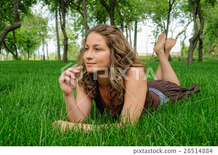Young pretty woman laying on the grass 28514884