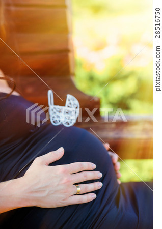 toy baby carriage on the belly of a pregnant woman toy baby carriage on the belly of a pregnant woman 28516750