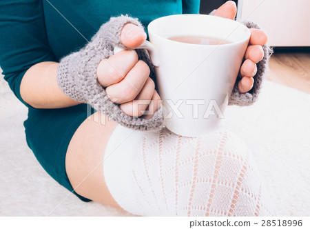 A girl holding a cup of tea A girl holding a cup of tea 28518996