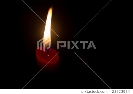 Red candle with yellow flame on black background 28523954