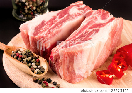 piece of pork on a dark background with peppercorn piece of pork on a dark background with peppercorn 28525535