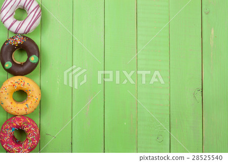 glazed donuts on a green wooden background with glazed donuts on a green wooden background with 28525540