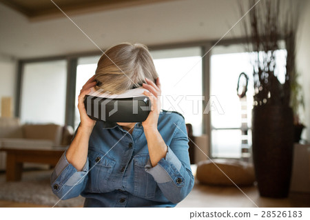 Senior woman wearing virtual reality goggles at 28526183
